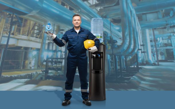 Operaio in fabbrica con un erogatore di acqua Acquaviva, leader nella distribuzione di acqua in boccioni e erogatori a rete idrica, in un ambiente di industria
