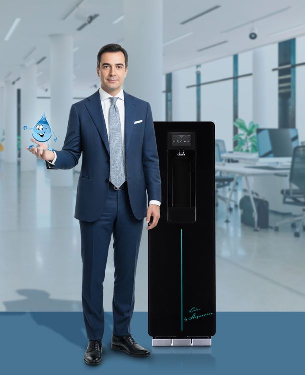 Professionista in ufficio con un erogatore di acqua Acquaviva, leader nella distribuzione di acqua in boccioni e erogatori a rete idrica, nel settore uffici e pubblica amministrazione